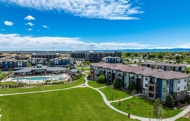 an aerial view of an apartment complex with a pool and green lawn at Arbour Commons, Colorado, 80023