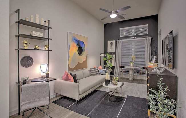 A living room with a white couch, a black shelf, and a painting on the wall.