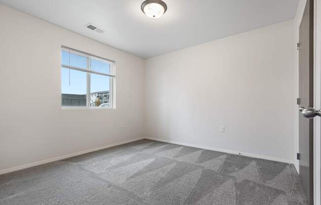 A room with a carpeted floor and a window.