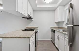 A kitchen with a granite countertop and stainless steel appliances.