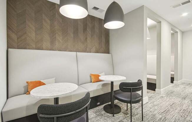 a seating area with two tables and two chairs in a room at Link Apartments® Calyx, Chapel Hill