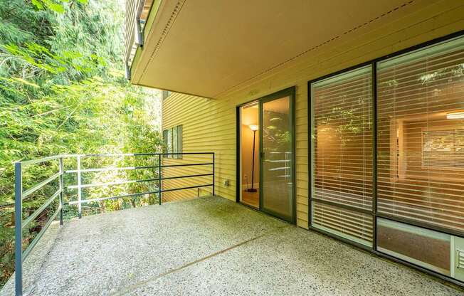 A patio area with a railing and sliding glass doors.