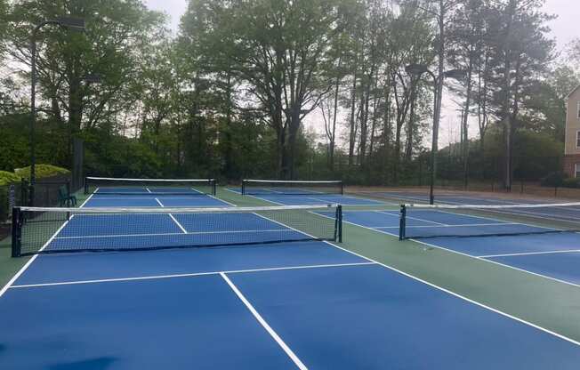 two tennis courts with nets on a blue court