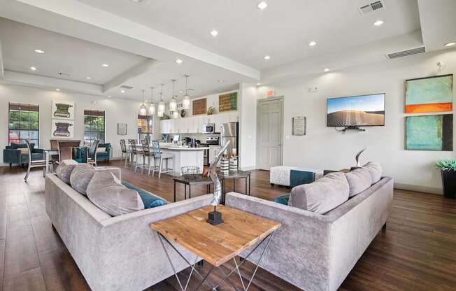 A modern living room with a large grey sofa and a wooden coffee table.
