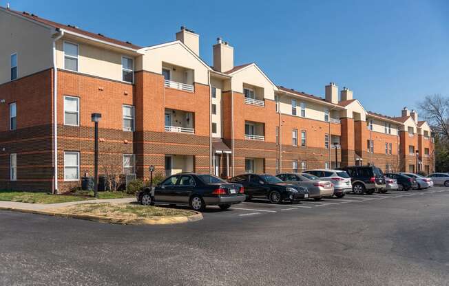 a row of brick apartment buildings with cars parked in front