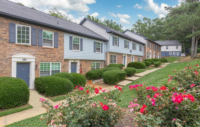 a close up of a flower garden in front of a brick building