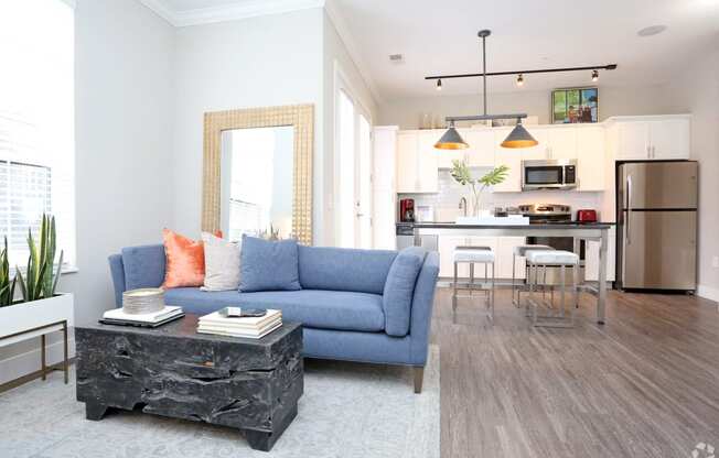 a living room and kitchen with a blue couch and a table at Century Baxter Avenue, Louisville