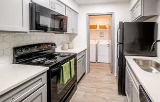 a kitchen with white cabinets and black appliances and a black refrigerator at 1900 Rosemont, Roswell, Georgia
