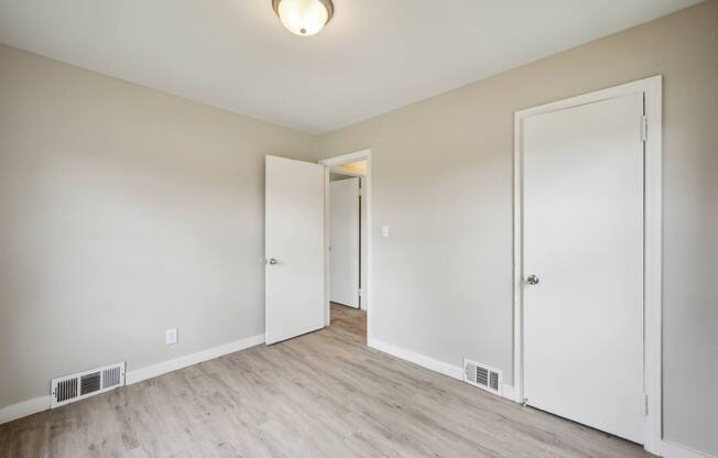 A room with white doors and a light on the ceiling.
