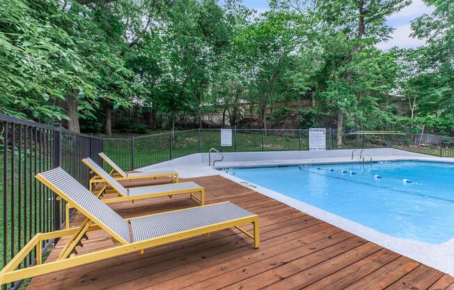 a wooden bench sitting next to a pool of water