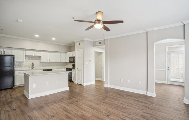 an empty living room and kitchen with a ceiling fan at The Verandah, Austin, TX, 78726