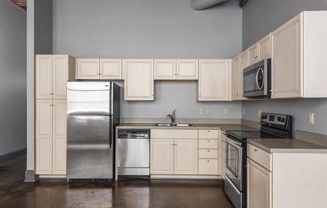 a kitchen with white cabinets and stainless steel appliances at East 4th Street, Cleveland, Ohio