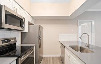 a modern kitchen with stainless steel appliances and white cabinets