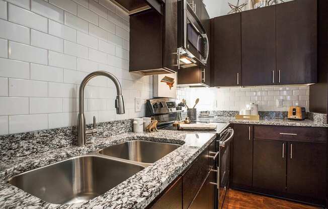 A kitchen with a sink and a microwave.