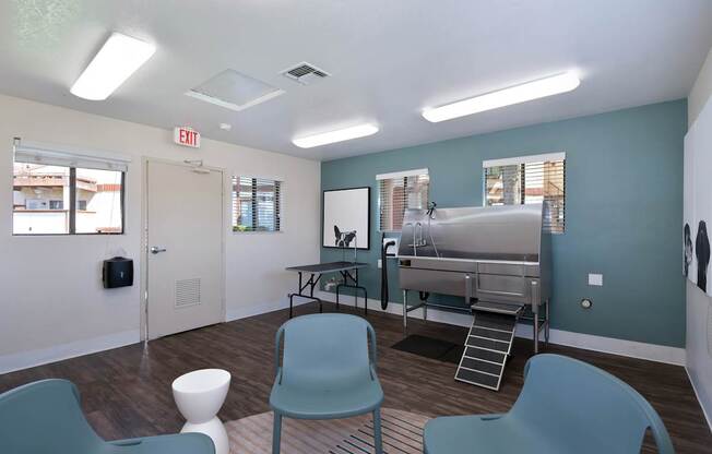 A room with a blue chair and a white stool.