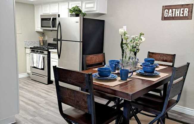A dining room with a table set for two and a sign that says "GATHER".
