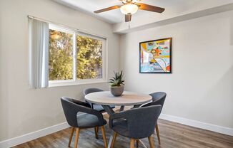 a dining room with a ceiling fan and three windows