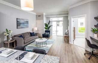 A modern living room with a dining table set for two.