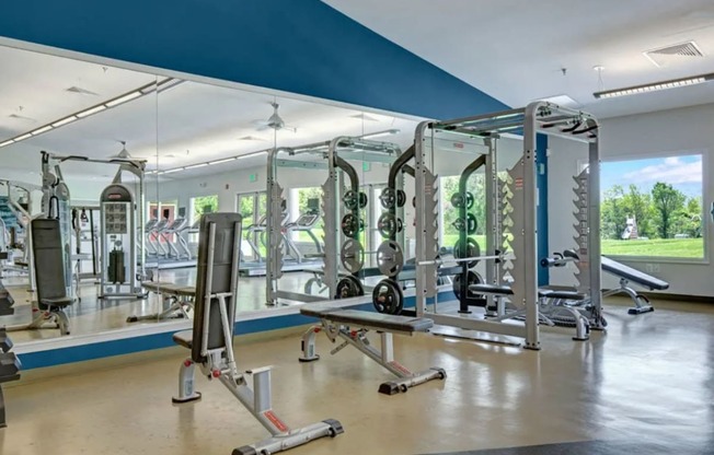 a gym with weights and other equipment in a building with a window