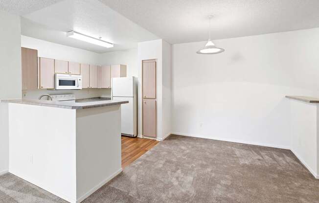 A kitchen with white cabinets and appliances.