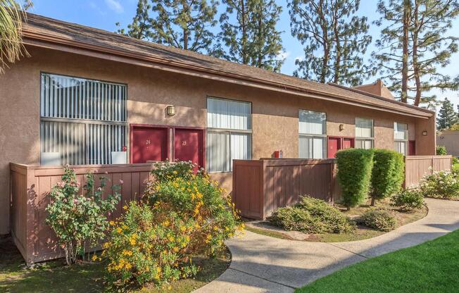 a house with bushes in front of a brick building