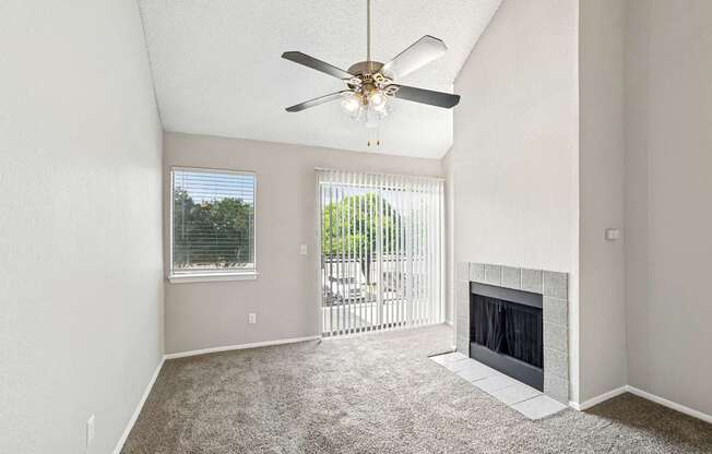 A room with a fireplace and a ceiling fan.