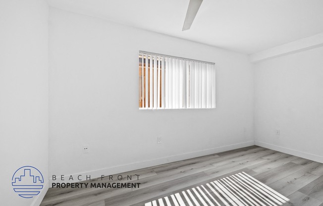 a living room with white walls and a window