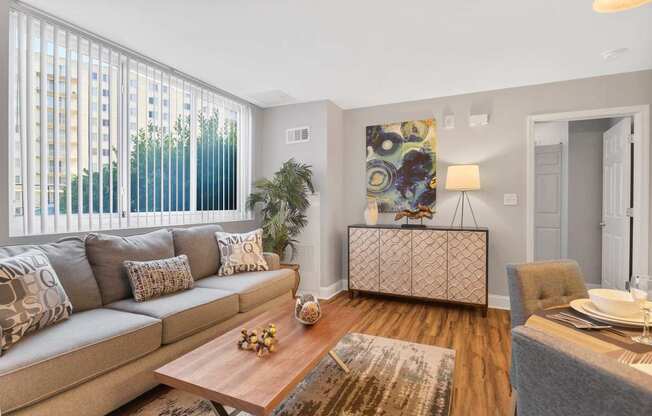 A living room with a grey couch, a wooden coffee table, and a grey rug.