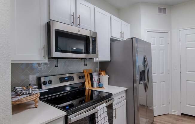 a kitchen with white cabinets and stainless steel appliances