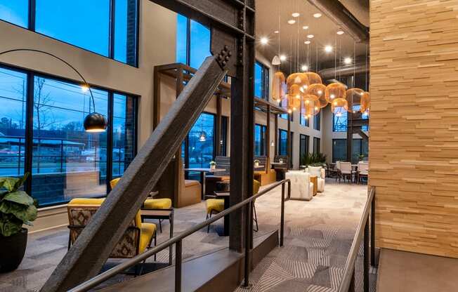 the lobby of the building has a large staircase and large windows