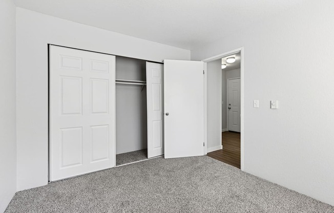 A room with a carpeted floor and a white door.