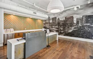 a lobby with a reception desk and a black and white photo of a city skyline at Link Apartments Innovation Quarter, Winston Salem