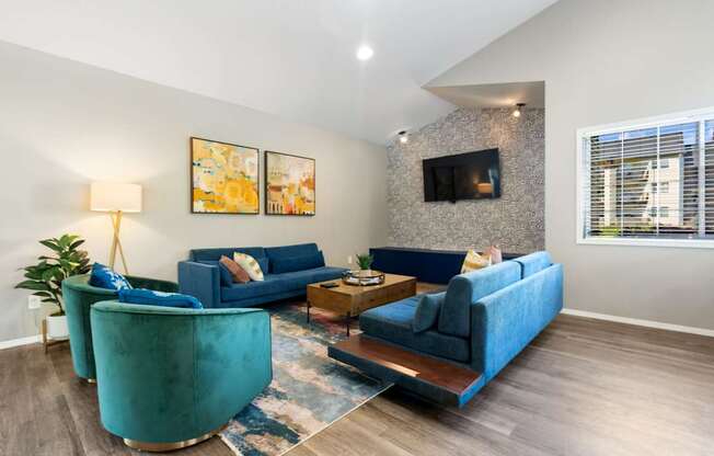 A living room with blue couches and a fireplace.