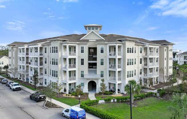 a large apartment building with cars parked in front of it