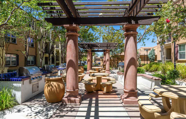 A patio with a table and chairs under a pergola.