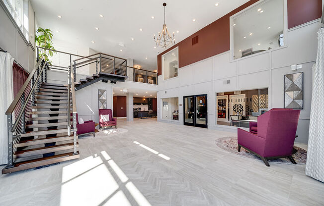 a large lobby with chairs and a staircase