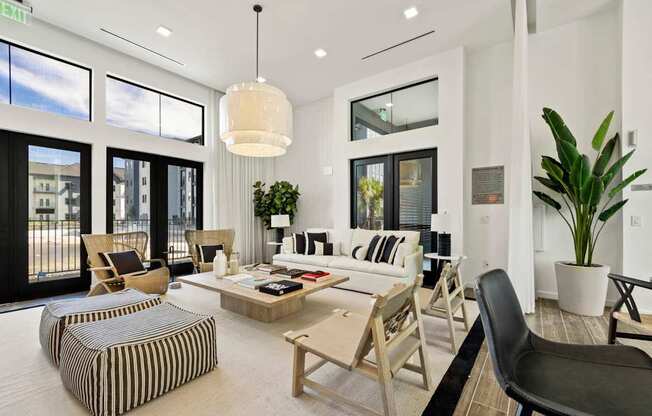 A living room with a large window and a striped ottoman.