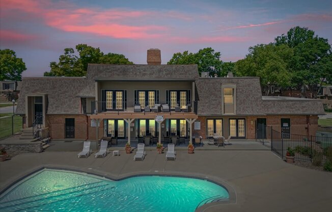A large house with a pool in front of it.