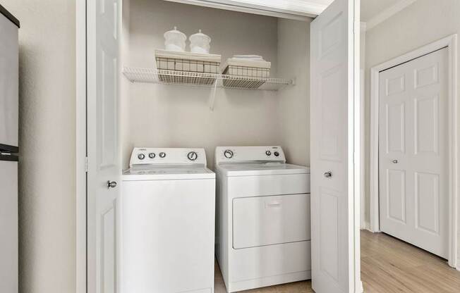 A white laundry room with a washer and dryer.