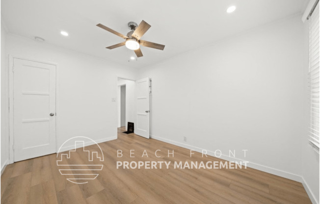 a living room with a ceiling fan and a door to a closet