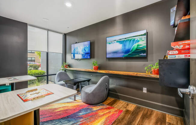 a conference room with a desk and two televisions on the wall
