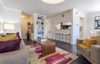 A living room with a grey couch and a wooden coffee table.at 2400 Briarwest Apartments, Houston, Texas
