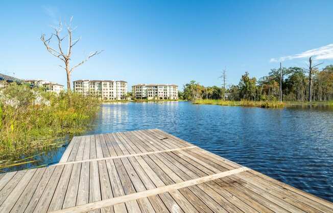 a dock on a lake with buildings in the background