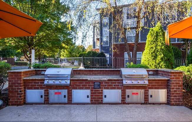 a brick barbecue with four ovens on it in front of a house