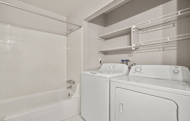 a white laundry room with a washer and dryer