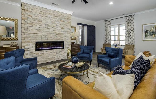 a living room with blue chairs and a fireplace