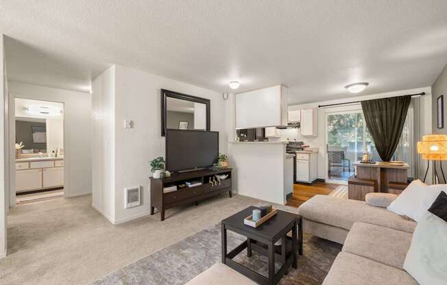 A modern living room with a flat screen TV and a coffee table at Clackamas Trails Apartments, Oregon, 97222