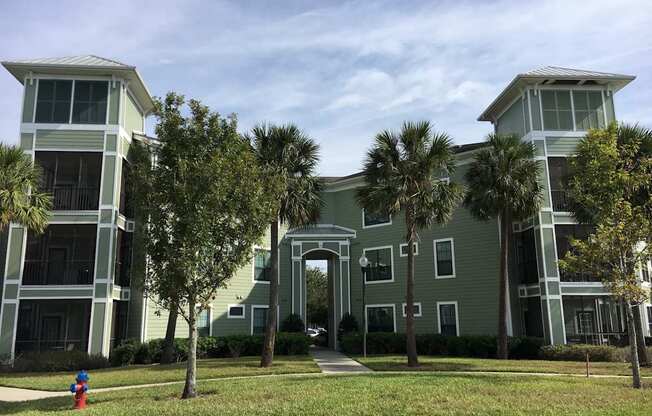 A fire hydrant is located on the grass in front of a building.