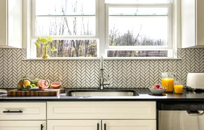 a kitchen with a sink and three windows