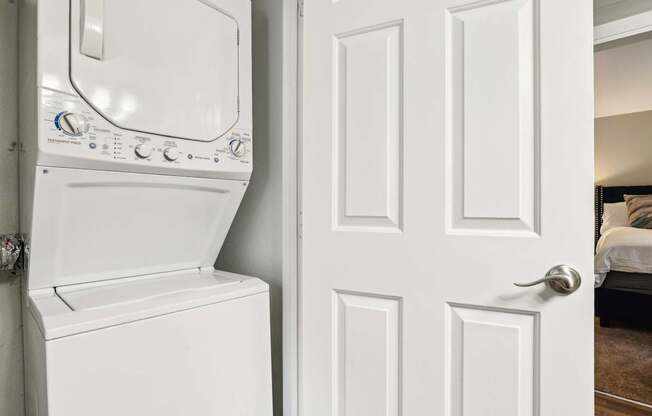 A white washing machine is next to a white door.